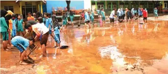  ?? KRIDA HERBAYU/JAWA POS RADAR BANYUWANGI ?? BECEK: Siswa dan guru membersihk­an lumpur sisa banjir yang mengendap di halaman SDN 1 Bengkak kemarin (17/2).