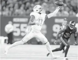  ?? BOB LEVEY/GETTY IMAGES ?? DeVante Parker makes a one-handed catch Thursday night against the Texans.