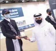  ??  ?? Ali Al Rumaihi, Event Director and Organizing Committee Member, Longines Hathab, honours Maryam Ahmad Al Boinin, winner of Level 1 dressage event of Longines Hathab Round 4 at Qatar Equestrian Federation’s indoor arena on Saturday.