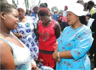  ??  ?? ABOVE: First Lady Auxillia Mnangagwa chats with Ms Pauline Sithole, who has been staying at Mbare Musika bus terminus with her family yesterday. BELOW: Ms Sithole prepares a meal for her children at her makeshift house