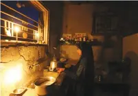  ?? (Ibraheem Abu Mustafa/Reuters) ?? A PALESTINIA­N GIRL cleans the kitchen of her house by candleligh­t during a power cut in the southern Gaza Strip.