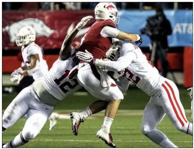  ?? Arkansas Democrat-Gazette/MITCHELL PE MASILUN ?? Arkansas quarterbac­k Ty Storey (center) gets hit as he throws by Ole Miss defensive tackle Austrian Robinson (left) and defensive end Tariqious Tisdale during the first quarter Saturday at War Memorial Stadium in Little Rock. Storey is in concussion protocol and will be evaluated throughout the week, Coach Chad Morris said Monday.