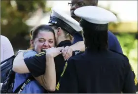  ?? KAREEM ELGAZZAR — THE CINCINNATI ENQUIRER VIA AP ?? A woman is comforted by authoritie­s stationed outside the University of Cincinnati Medical Center’s Emergency room following a shooting in downtown Cincinnati that left at least four dead and several injured, Thursday in Cincinnati.