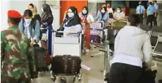  ?? HANUNG HAMBARA/JAWA POS ?? IKUTI PROTOKOL: Para pekerja migran di Hongkong tiba di Terminal 3 Bandara Soekarno-Hatta kemarin (14/5). Mereka akan dikarantin­a di Asrama Haji Pondok Gede selama 14 hari.