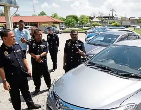  ??  ?? On the wrong side of the law: adenan (left) and his officers inspecting some of the impounded e-hailing vehicles.