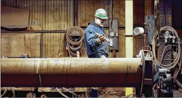  ?? ROSS MANTLE / THE NEW YORK TIMES ?? A man works last month at the CP Industries plant in McKeesport, Pa. The nation’s economy added 164,000 jobs last month, up from the 135,000 it added in March.