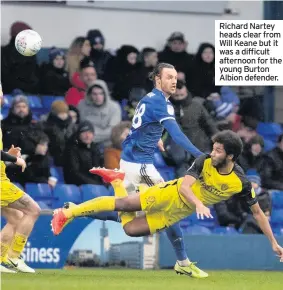  ??  ?? Richard Nartey heads clear from Will Keane but it was a difficult afternoon for the young Burton Albion defender.