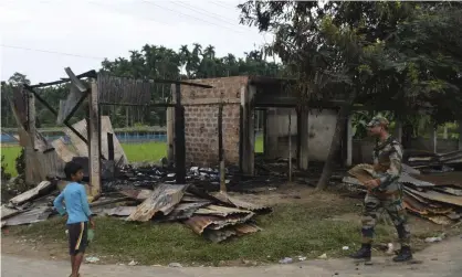  ?? ?? A soldier walks past a shop that was set on fire in Rowa village in the north-eastern Indian state of Tripura last month. Photograph: Panna Ghosh/AP