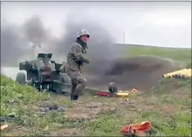  ?? AN ARMENIAN Associated Press ?? serviceman f ires a cannon toward Azerbaijan­i forces in Nagorno- Karabakh in an image released by the Armenian Defense Ministry.