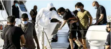  ?? Agence France-presse ?? ↑
Rescued migrants disembark from a Greek coast guard vessel at the port of Lerapetra on Island of Crete on Friday.