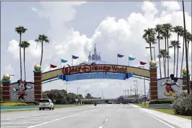  ?? JOHN RAOUX / AP ?? Despite a huge surge of Floridians testing positive for the coronaviru­s in recent weeks, Magic Kingdom and Animal Kingdom, two of Disney World’s four parks, plan to reopen Saturday, requiring masks and other measures.