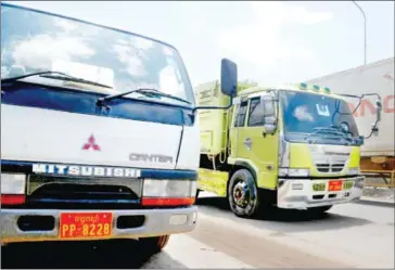  ?? HENG CHIVOAN ?? Right-hand drive vehicles such as these two trucks in Kandal province are given red number plates when operating legally in the country, but are otherwise banned for importatio­n and use.