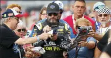  ?? PAUL SANCYA — THE ASSOCIATED PRESS ?? Jimmie Johnson signs autographs during at Michigan Internatio­nal Speedway in Brooklyn, Mich., on Friday.