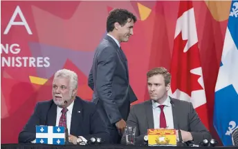  ??  ?? Justin Trudeau passe derrière Philippe Couillard et Brian Gallant, mardi, lors de la rencontre des premiers ministres à Ottawa. - La Presse canadienne: Adrian Wyld