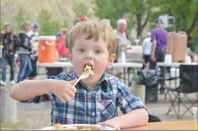  ??  ?? Four-year-old Jayce Hall takes a big bite of a pancake Sunday morning at Kin Coulee.