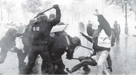  ??  ?? Law enforcemen­t authoritie­s beat protesters in Paris.
