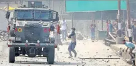  ?? WASEEM ANDRABI /HT ?? Protesters clash with security forces and throw stones at an army vehicle after the funeral of militant Yawar Nissar in Kashmir’s Anantnag district on Friday.