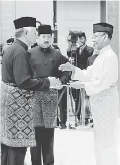  ??  ?? NEW TERM: The Agong presents the letter of appointmen­t to Najib at Istana Negara. — Bernama photo