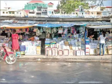  ?? SCOTT HOWES ?? Vendors sell books at stalls along the street in Phnom Penh in 2013.