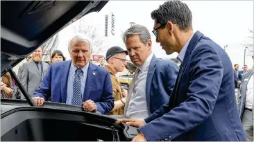  ?? NATRICE MILLER/NATRICE.MILLER@AJC.COM ?? Georgia House Speaker Jon Burns (left), Gov. Brian Kemp and Rivian CEO R.J. Scaringe check out a Rivian electric vehicle Wednesday after a news conference marking Rivian Day at the Georgia Capitol.