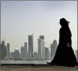  ?? PHOTO/KAMRAN JEBREILI ?? In this May 14, 2010, file photo, a Qatari woman walks in front of the city skyline in Doha, Qatar. AP