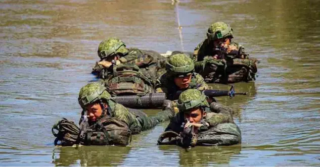  ?? PHOTOGRAPH FROM THE PHILIPPINE ARMY OFFICER CANDIDATE SCHOOL ?? SOLDIERS navigate a river as part of combat training in an undated photo. Col. Louie Dema-ala, Philippine Army spokespers­on, said the organizati­on needs more than just “warriors” amid the evolving security needs and external threats.