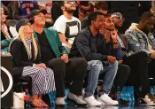  ?? MIKE LAWRIE / GETTY IMAGES ?? Masters champion Patrick Reed, with wife Justine (left) and comedian Chris Rock along with other celebritie­s, wears his green jacket to the Knicks-Cavs game Monday at Madison Square Garden.