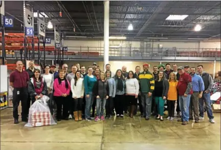  ?? SUBMITTED PHOTO ?? More than 30 Vanguard volunteers get ready to load gifts onto agency trucks for Vanguard’s annual Sponsor-A-Child initiative.