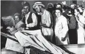  ?? AP 1934 ?? People view the body of gangster John Dillinger in a Chicago morgue. Two relatives are having his body exhumed.