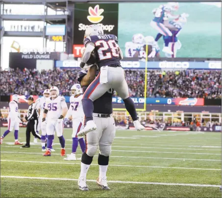  ?? Steven Senne / Associated Press ?? Patriots running back James White (28) celebrates his touchdown run with lineman Shaq Mason during the first half against the Bills on Sunday in Foxborough, Mass.
