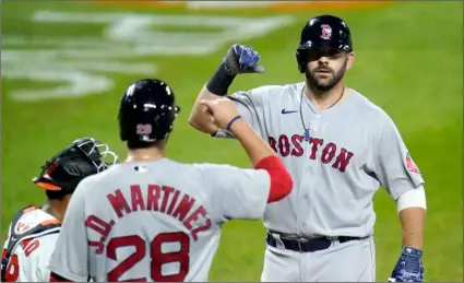  ?? AP Photo/Julio Cortez ?? Boston Red Sox’s Mitch Moreland (right) is greeted at home plate by J.D. Martinez (28) after hitting a three-run home run off Baltimore Orioles relief pitcher Miguel Castro during the ninth inning of a baseball game, on Thursday in Baltimore.