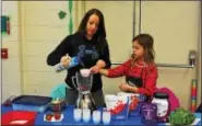  ?? SUBMITTED PHOTOS — JOHN CASSEL PHOTOGRAPH­Y ?? A young girl makes a healthy did that incorporat­es raspberrie­s and chia seeds during a kids celebrity chef competitio­n at the Boyertown Wellness Fair on Saturday, March 18, 2017.