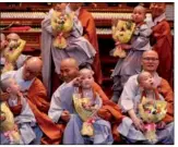  ?? KIM HONG-JI / REUTERS ?? Novice monks who had their heads shaved pose for photograph­s with Buddhist monks during an event to celebrate the upcoming Vesak Day, the birthday of Buddha, at Jogye temple in Seoul, South Korea, on Wednesday.