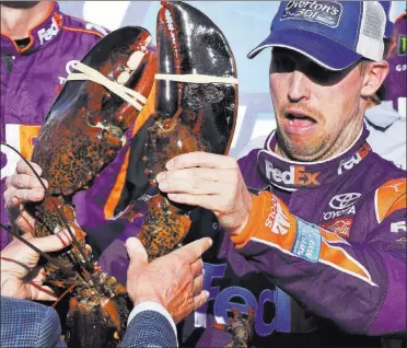  ?? Charles Krupa ?? NASCAR
Cup driver
Denny Hamlin hesitantly touches the ceremonial lobster awarded to the winner of the Overton’s
301 on Sunday at New Hampshire Motor Speedway in Loudon,
N.H. Hamlin’s 30th career Cup victory ended a winless streak that stretched to...