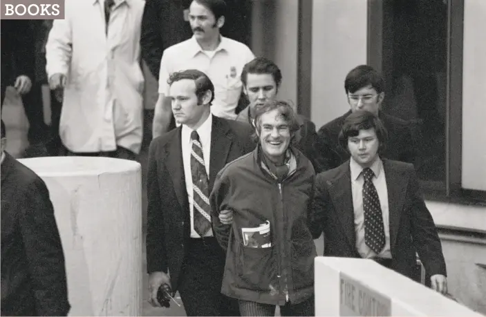  ?? Bettmann / Getty Images 1972 ?? Timothy Leary laughs as he is escorted by federal officers after arriving in California from London, more than two years after escaping from prison.