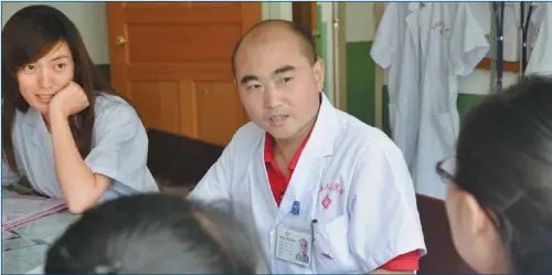  ?? LIU XIANGRUI / CHINA DAILY ?? Doctor Deng Shengming has a meeting with his colleagues at Medog’s county hospital.