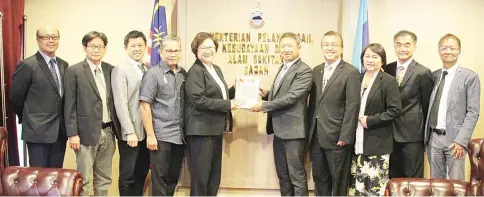  ??  ?? Benny (fifth from right) presenting a memento to Liew during the courtesy call.