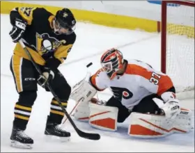  ?? GENE J. PUSKAR - AP ?? Philadelph­ia Flyers goalie Brian Elliott (37) blocks a shot by the Pittsburgh Penguins’ Sidney Crosby (87) in the first period of an NHL game in Pittsburgh, Monday.