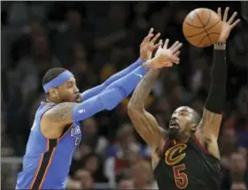  ?? TONY DEJAK — THE ASSOCIATED PRESS ?? Oklahoma City Thunder’s Carmelo Anthony, left, passes over Cleveland Cavaliers’ JR Smith in the first half of an NBA basketball game, Saturday in Cleveland. The Thunder won 148-124.