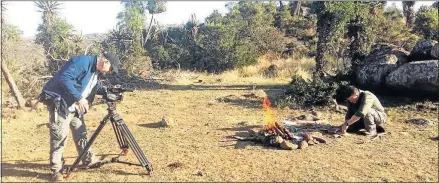  ??  ?? FOLLOWING TRADITION: Steve Townley Bassett, right, demonstrat­es the way the ancient stone age artists used fire to make their paints, filmed for a documentar­y by a cameraman from CNN