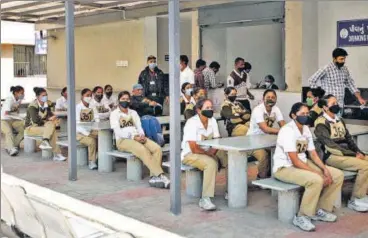  ?? PTI ?? Police personnel wait for their turn to get registered for the first dose of Covid-19 vaccine in Ahmedabad on Sunday.