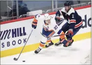  ?? Nick Wass / Associated Press ?? Islanders left wing Anders Lee (27) skates with the puck past Capitals defenseman Justin Schultz on Tuesday.