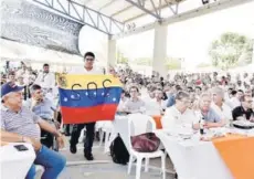  ??  ?? ► Un hombre con una bandera de Venezuela con las letras SOS en una actividad el sábado, en Malambo.