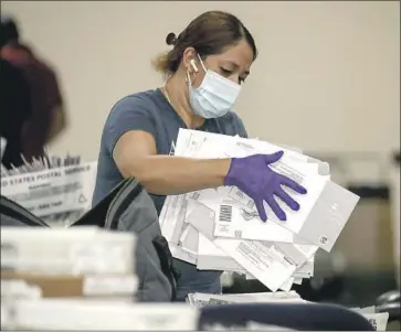  ?? Irfan Khan Los Angeles Times ?? ELECTION WORKER Yolanda Lavayen unbags ballots in Pomona in the Sept. 14 recall election. In the aftermath of the vote, which cost taxpayers $276 million, there has been no shortage of calls to reform the recall.
