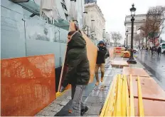  ?? Reuters ?? Workers barricade a shop window with wood panels on the Champs-Elysees near the Arc de Triomphe on the eve of a ‘yellow vests’ protest in Paris yesterday.