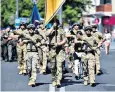  ?? ?? Azov soldiers march along a street in Mariupol, where the regiment is based