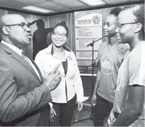  ?? IAN ALLEN/PHOTOGRAPH­ER ?? Dalton Wint (left), general secretary, Jamaica Football Federation (JFF), making a point to S.C. Monarch’s Mahalia Garvey (right) and Stephanie Morgan (second right) at the launch of the 2018 women’s football league and knockout competitio­ns. Looking...