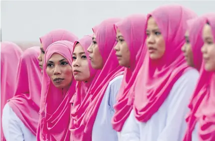  ?? REUTERS ?? Women members of Malaysia’s ruling United Malays National Organisati­on party wait for Prime Minister Najib Razak to arrive for the annual assembly at the Putra World Trade Centre in Kuala Lumpur, Malaysia, yesterday.