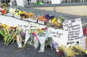  ?? Candice Choi / Associated Press ?? A makeshift memorial of flowers in Atlanta honors victims of the shooting rampage that killed eight people, including six women of Asian descent.