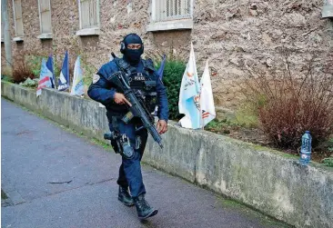  ?? [AP PHOTO] ?? A hooded police officer patrols outside the Fresnes prison where terrorism suspects were expected to be jailed, outside Paris.